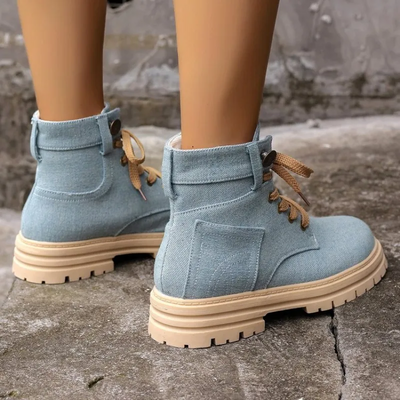 Rear view of women's blue canvas lace-up ankle boots with beige platform soles.