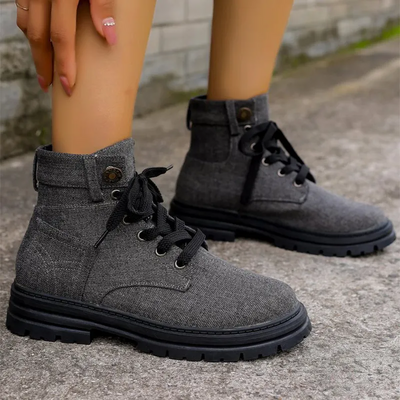 Close-up of women's gray canvas lace-up ankle boots with black soles.