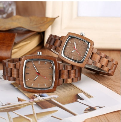 His and hers wooden watches with square faces and wooden link bands.