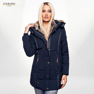 A woman wearing a navy blue puffer coat with a faux fur-lined hood. The coat has a zippered front and pockets.