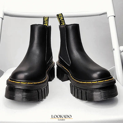 Front view of a pair of women's black platform Chelsea boots with a chunky sole and classic design.