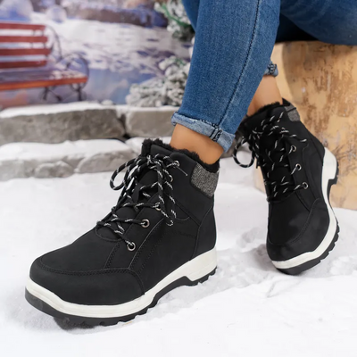 Woman wearing black winter boots with warm lining.