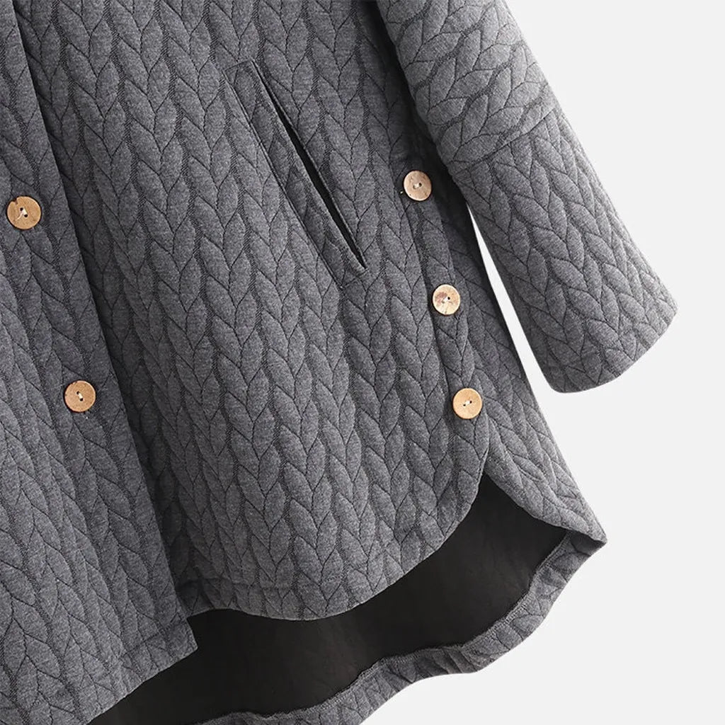 Close-up of the button detail and stitching on a grey quilted coat.