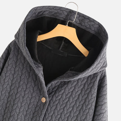 Close-up of the hood and button detail on a grey quilted coat.