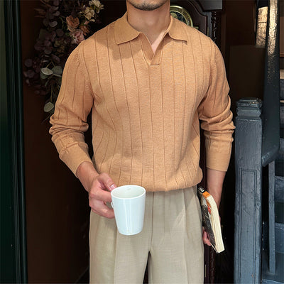 Close-up of a men's beige knit sweater with a collared neckline and ribbed texture, paired with beige trousers.