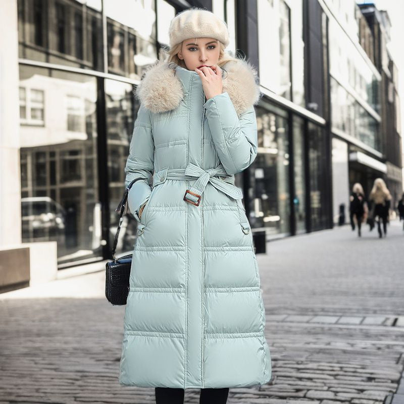 A woman is dressed in a light blue down coat, showcasing a cozy and fashionable winter look.